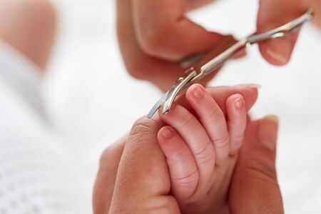 Close up of mother cutting baby's nailsの写真素材