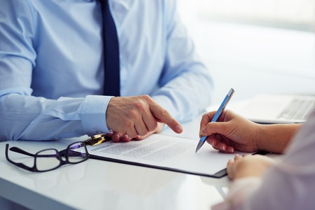 Male boss recommends that his employee sign a contract in the office.の写真素材
