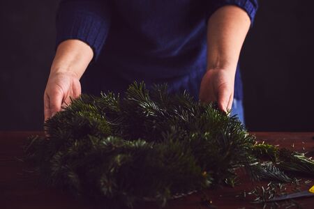 Florist makes a traditional Christmas wreathの写真素材