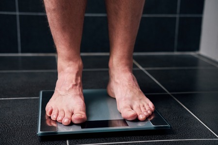 Male feet on the scale in the bathroomの写真素材