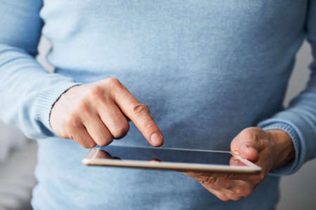 Man working on a digital tablet near a window