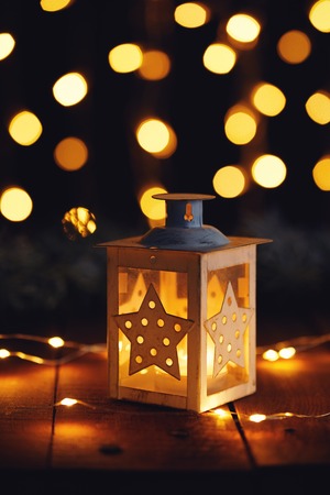 Christmas lantern with lights on a wooden board