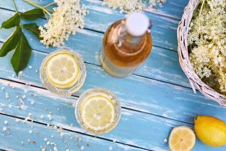 Top view of elderberry lemonade with bottle of syrup and elderberry flowers on wooden tableの写真素材