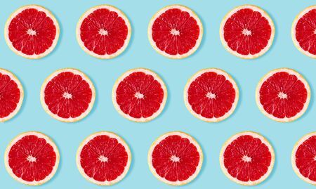 Fruit pattern from slices of grapefruit on blue backgroundの写真素材
