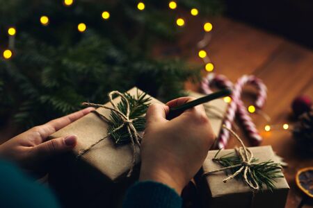 Woman writes names on Christmas giftsの写真素材