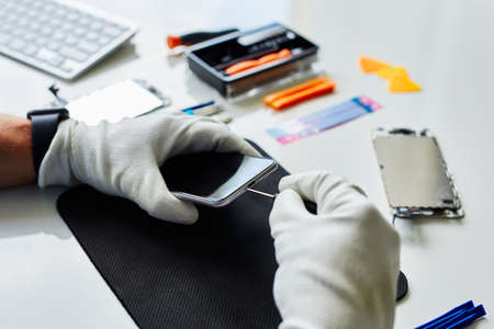 A man repairs a cell phone in a repair shop
