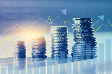 Coins in piles with investment appreciation chartの写真素材