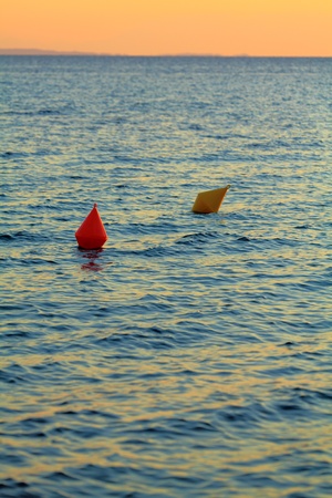 Red and yellow buoys during sunsetの写真素材
