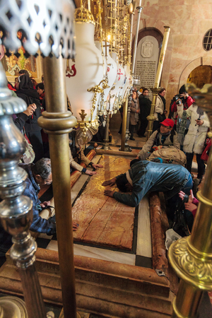 JERUSALEM, ISRAEL - FEBRUARY 16, 2013: Pilgrims praying near Stone of Unction at entrance in Church of the Holy Sepulchreのeditorial素材