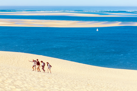 AQUITAINE, FRANCE - APRIL 5, 2011: Group of tourists walking on the highest dune in Europe - Dune of Pyla (Pilat)のeditorial素材