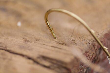 A fishing hook stuck in the wooden Board closeupの写真素材
