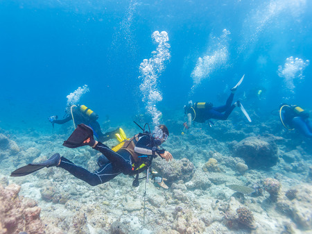 Group of underwater scuba divers with native guide, Maldives