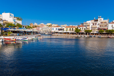 AGIOS NIKOLAOS, CRETE - AUGUST 1, 2012: Tourists walking in city center and Voulismeni Lake before...
