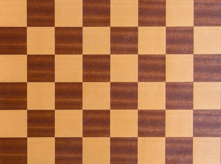 Black and white squares of a wooden chessboard background