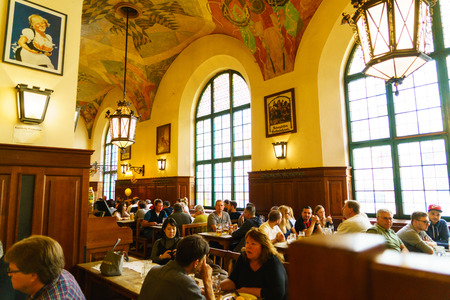 MUNICH, GERMANY - OCTOBER 14, 2017: Interior of main beer restaurant Hofbrauhaus with tourists and football funsのeditorial素材