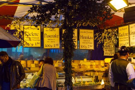 Munich, Germany - October 14, 2017: Tourists buy different kinds of cheese on the counter of the Viktualienmarkt marketのeditorial素材