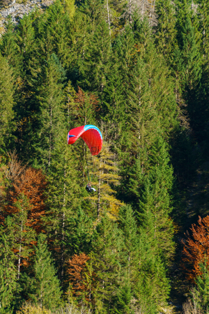 An athlete on a paraglider landing after a jump with one of the alpine peaks, Berner Oberland, Switzerlandの写真素材