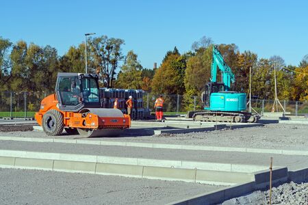 Munich, Germany - October 16, 2017: Builders in uniform work at a construction site near the paver...
