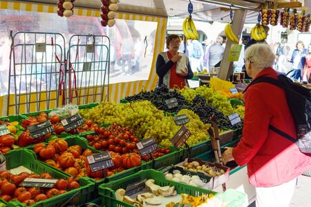Bern, Switzerland - October 17, 2017: Swiss men and women buy fresh vegetables and fruits in the city marketのeditorial素材
