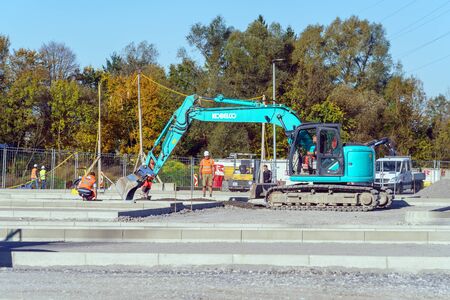 Munich, Germany - October 16, 2017: Builders in uniform work at a construction site near the paver...