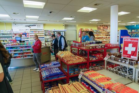 Geneva, Switzerland - October 18, 2017: Buyers stand at the cash desk of a small Swiss grocery store