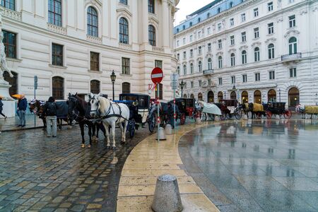 Vienna, Austria - October 22, 2017: Traditional carriages with horses waiting for tourists in the square in front of Hofburgのeditorial素材