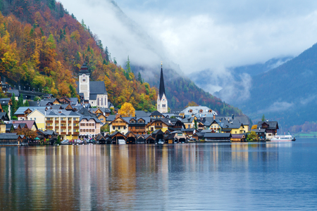 Lake view of famous Hallstatt village in Salzkammergut area at Autumn misty day, Austriaの写真素材