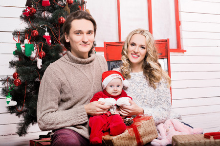 family in a christmas decorated room with a christmas treeの写真素材