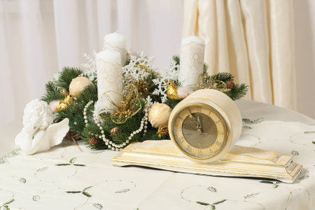 decorated christmas wreath on a table with an antique designer clockの写真素材