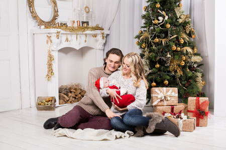 christmas family in a christmas decorated room with a christmas tree and a fireplaceの写真素材