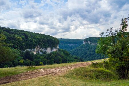 Dirt road on the edge of the cliff in mountain regionの写真素材