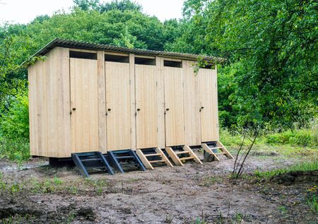 Five new wooden toilet camping in a village among the treesの写真素材