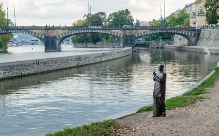 Statue of a praying monk in harmony on the banks of the Vltava River on Kampa Island in Prague, Czech Republic.の写真素材