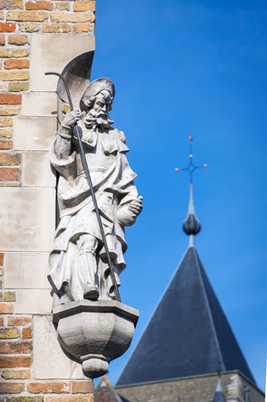 Saint men sculpture on the corner of the house in Brugge, Belgiumの写真素材