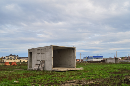 An abandoned concrete box in the field is used as a house.の写真素材