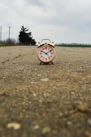 Time Concept Alarm Clock on the Asphalt Street.
