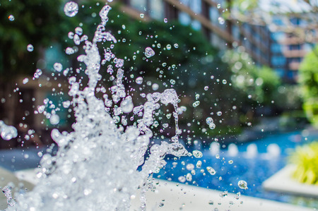 Freeze splashing droplets of water in the air near the swimming pool, close up imageの写真素材