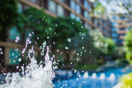 Freeze splashing droplets of water in the air near the swimming pool, close up imageの写真素材
