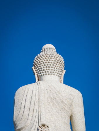 Back view of the white marble statue of Big Buddha on blue sky background.の写真素材