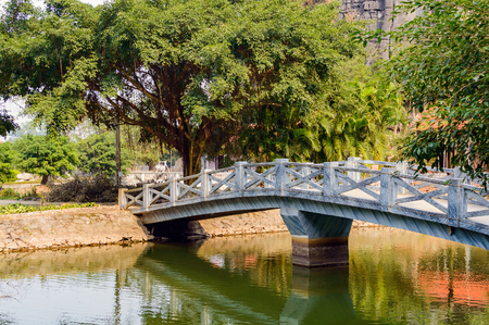 Scenic view of bridge over canal with green water in tropical garden at Ninh Binh Province, Vietnam. Ninh Binh Province is a popular tourist destination of Asia.の写真素材