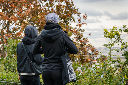 Two girls in black clothes views from terrace of Sacre Coeur Cathedral, the highest city point of Paris, France, Europe.のeditorial素材