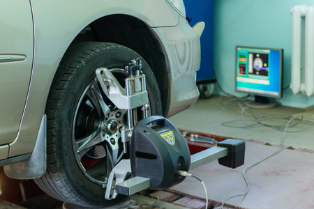 Car on stand with sensors on wheels for wheels alignment camber check in workshop of Service station.の写真素材