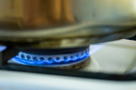 Burning gas of a kitchen stove. Blue fire under iron pot.の写真素材