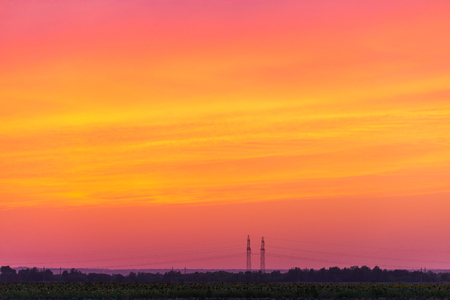 Rural landscape with high-voltage line on sunset. Dramatic sky viewの写真素材