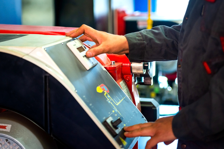 Technician at work. Servicing water heating systems. Man's hand on control panel of gas boiler burnerの写真素材