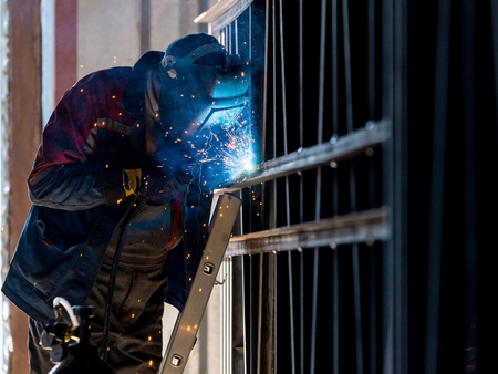 Industrial Worker labourer at the factory arc welding steel structure.の写真素材