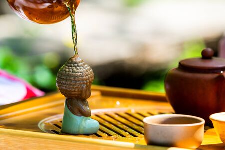 Tea ceremony. Teapot and bowls with Chinese tea on a wooden table.