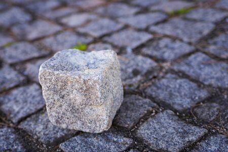 Stone cube on paving stone surface of walkway in Europeの写真素材