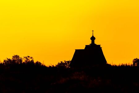 Sunset church cross silhouette in sunset sky clouds. Sunset church silhouette. Sunset sky clouds panoramaの写真素材