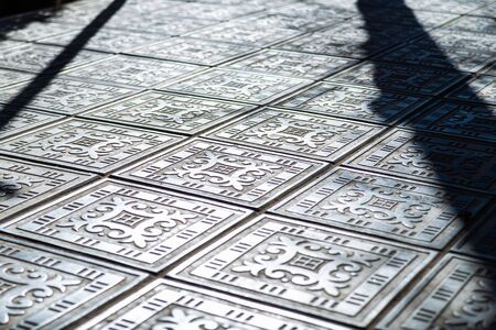Patterns on large metal floor plates on a street of city.の写真素材